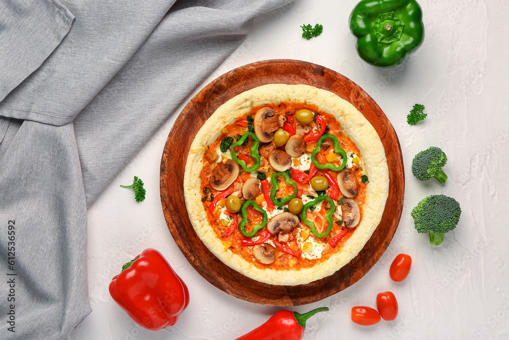 Board with vegetable pizza and ingredients on white background