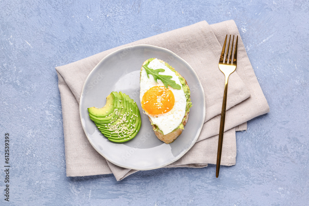 Plate of tasty bruschetta with avocado and egg on grey background