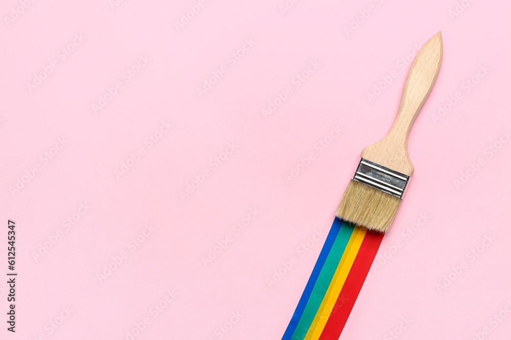 Paint brush with adhesive tapes on pink background