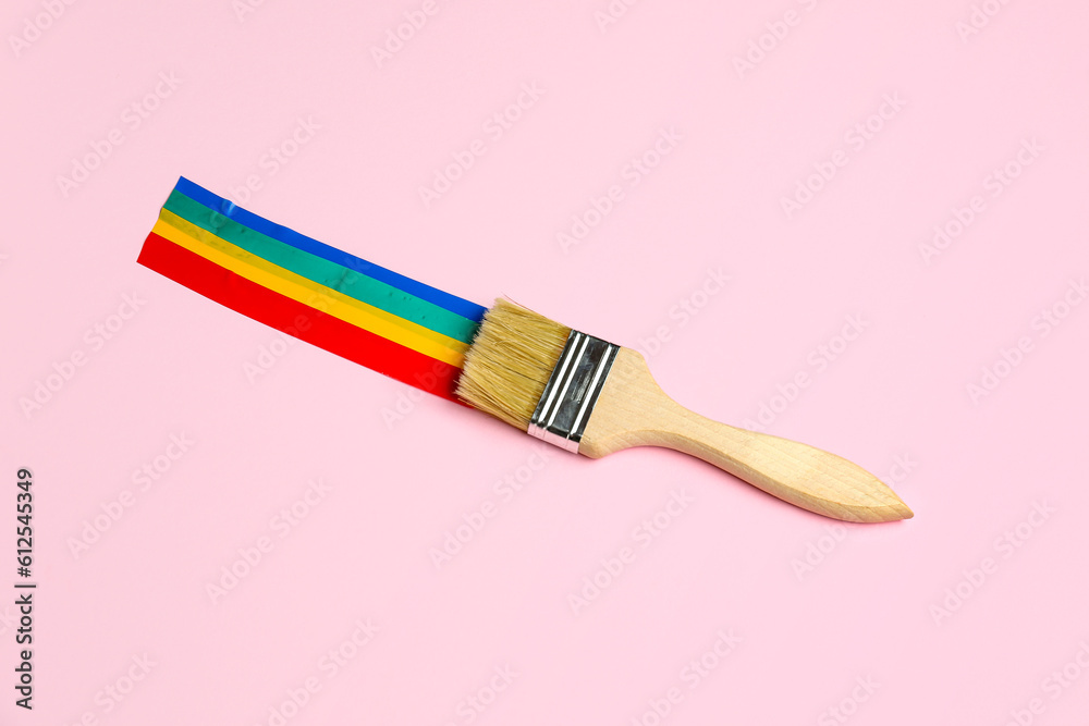 Paint brush with adhesive tapes on pink background