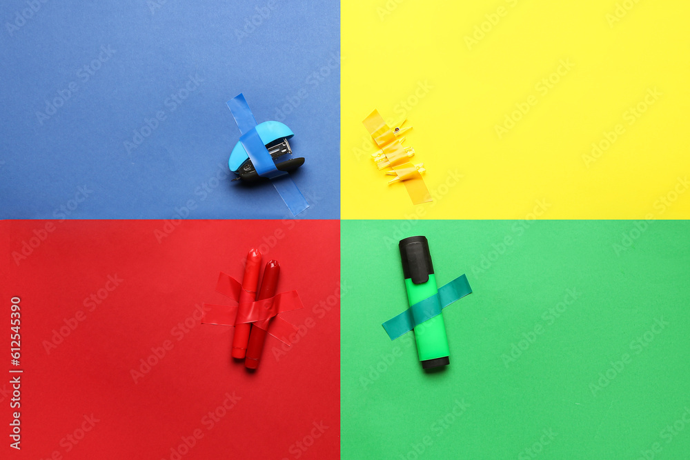 Stationery supplies with adhesive tapes on color background