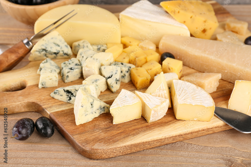 Board with pieces of tasty cheese on table