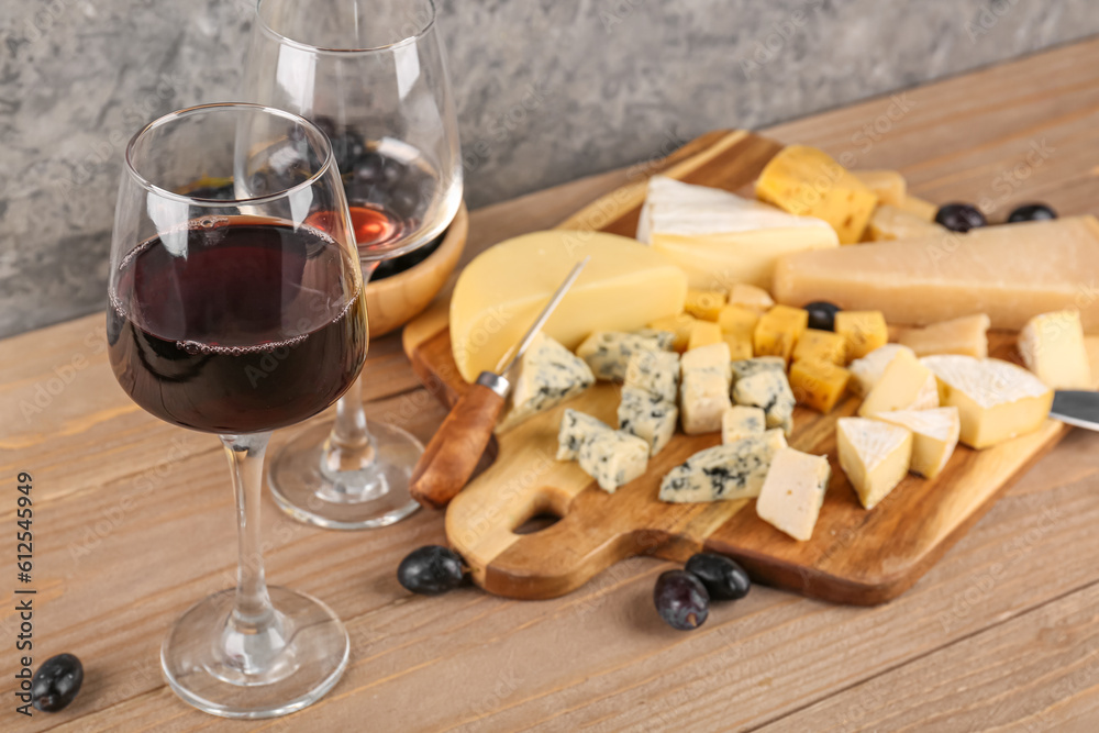 Pieces of tasty cheese and glasses with wine on table