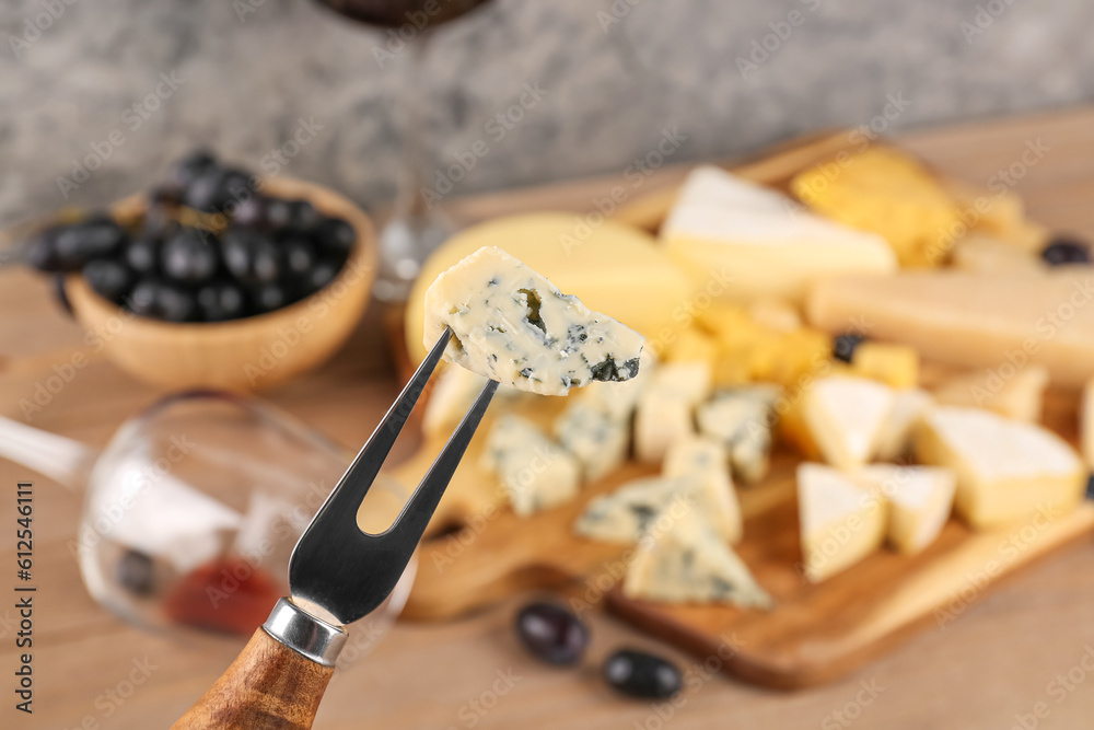 Fork with piece of tasty cheese, closeup