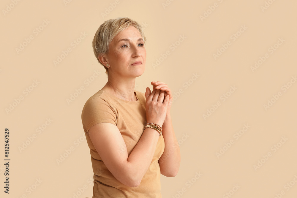 Mature blonde woman on beige background