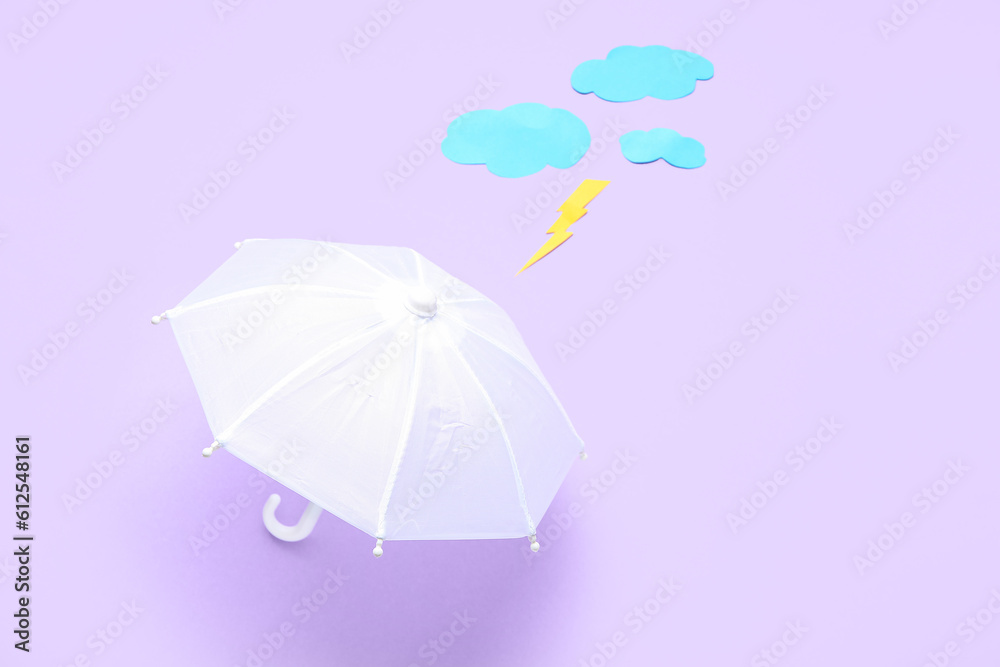 Composition with umbrella, paper clouds and lightning on lilac background