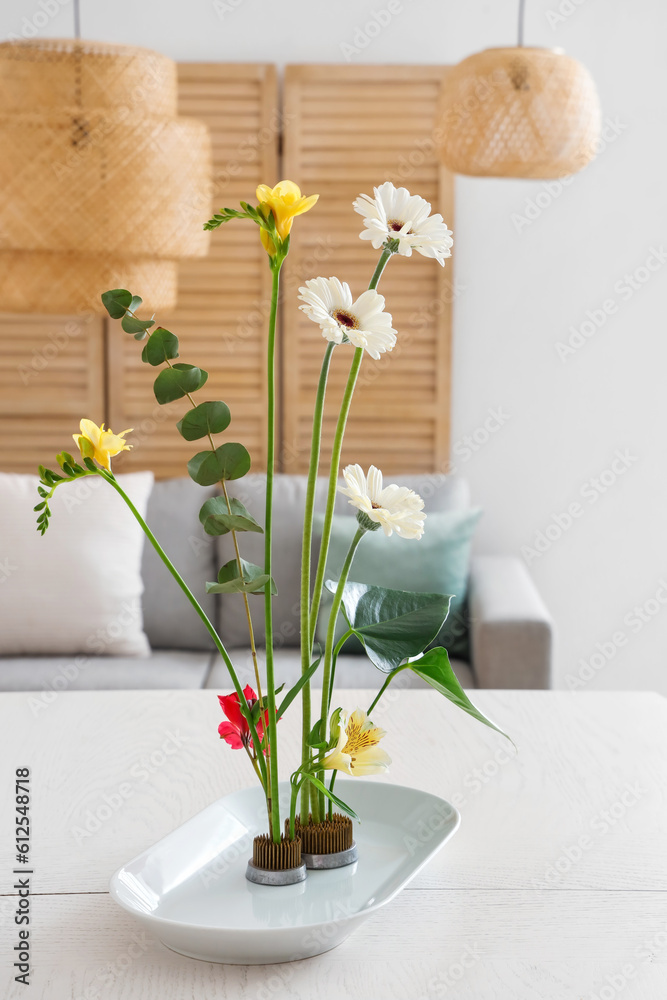 Beautiful ikebana on dining table in room