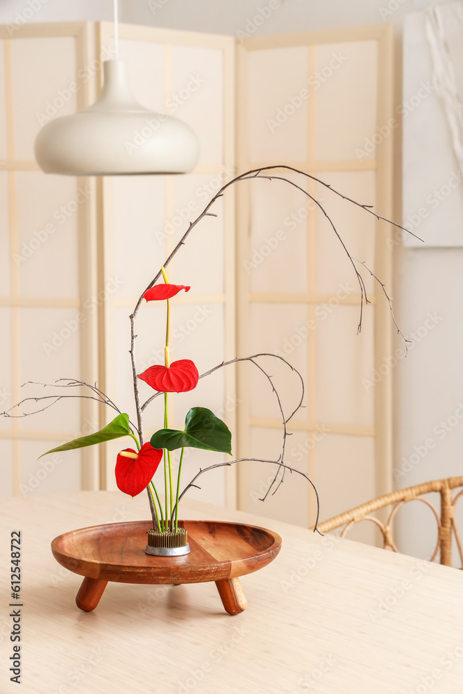 Beautiful ikebana on dining table in room