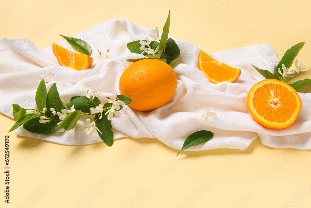 Oranges with blooming branches on beige background