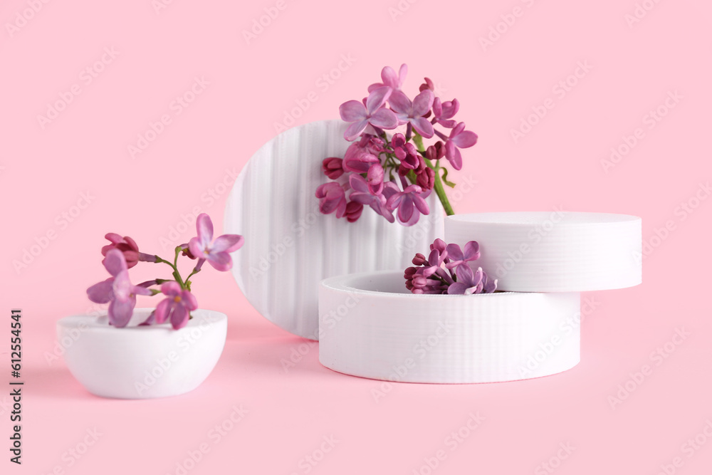 Lilac flowers with plastic figures on pink background