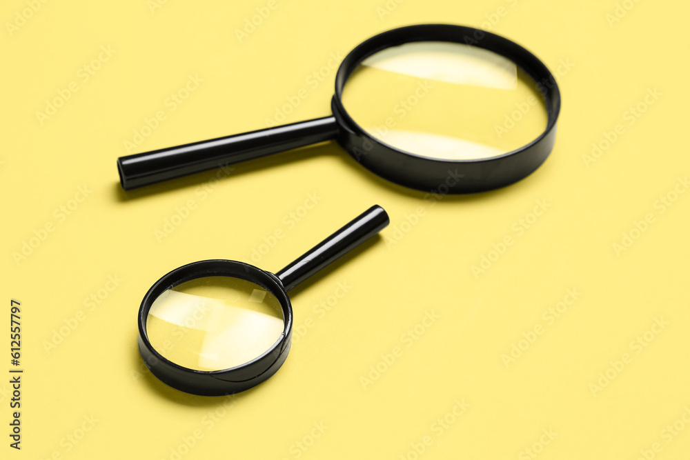 Black magnifiers on yellow background