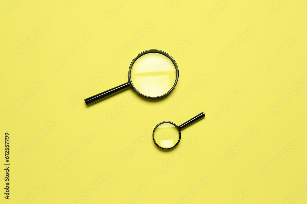 Black magnifiers on yellow background