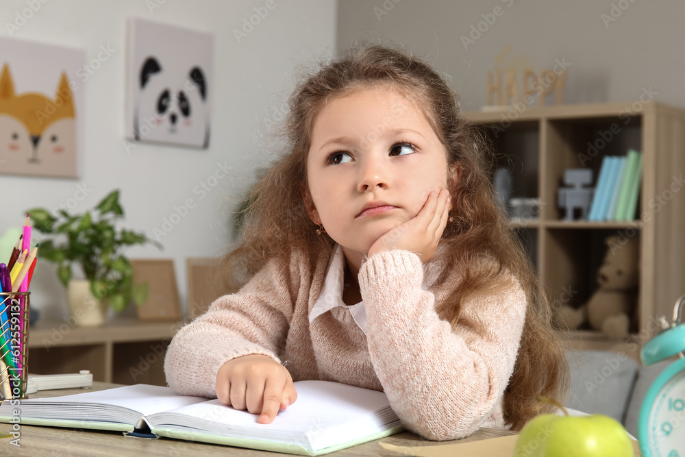 Cute little girl reading book at home