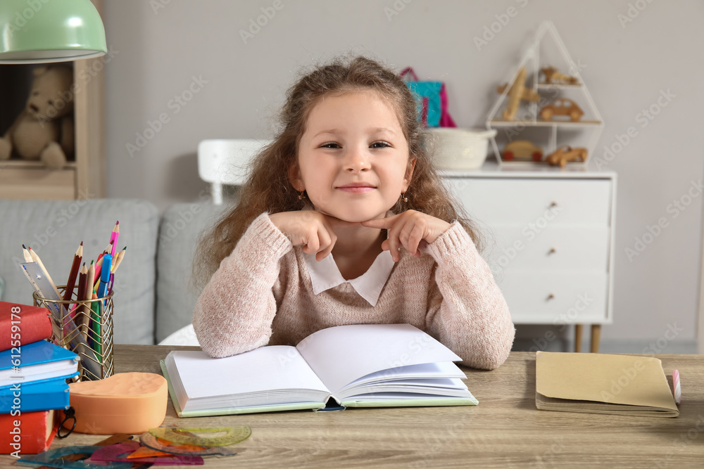 Cute little girl reading book at home