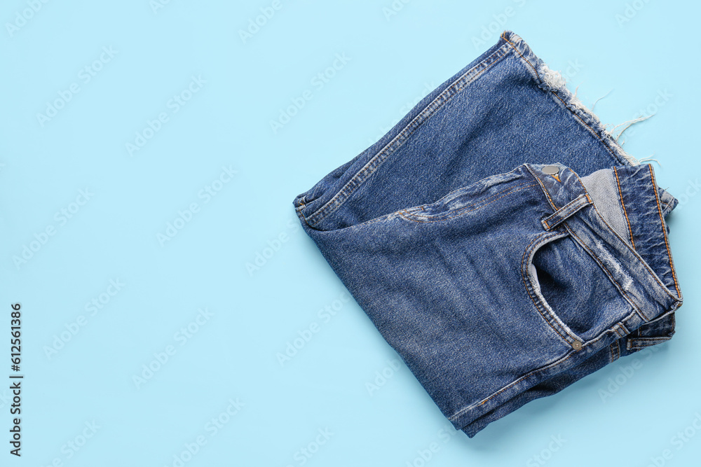 Stylish denim jeans on blue background