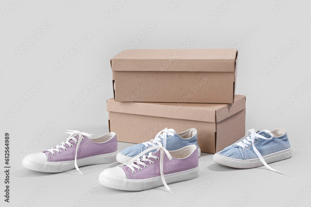 Cardboard boxes with different stylish sneakers on white background