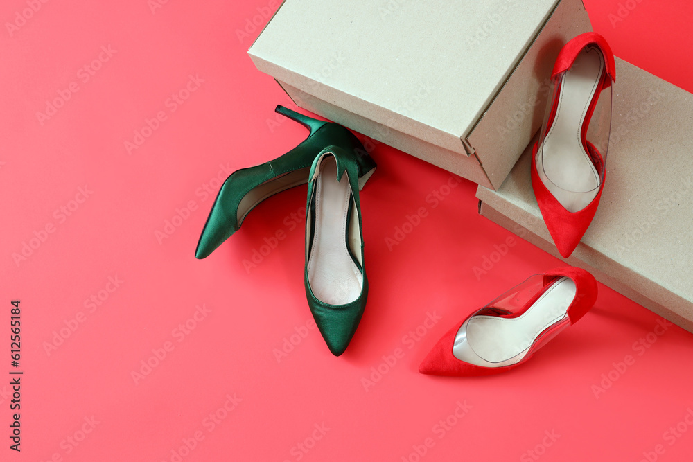 Cardboard boxes with different high-heeled shoes on red background