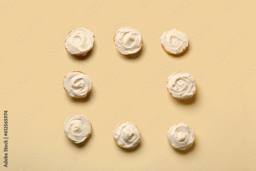 Frame made of tasty croutons with cream cheese on yellow background