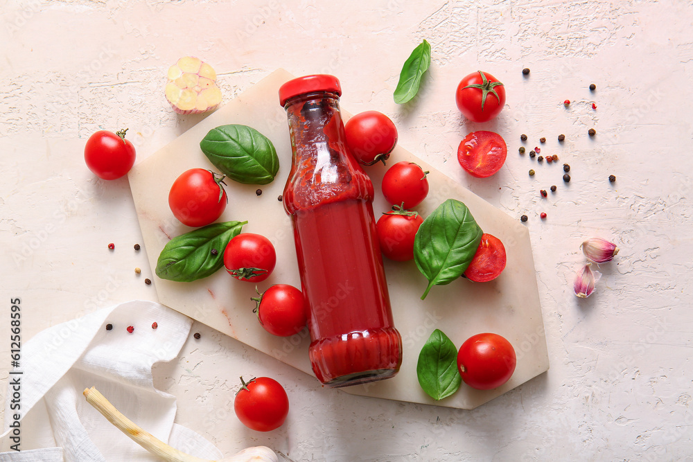 Board with glass bottle of ketchup and tomatoes on white background