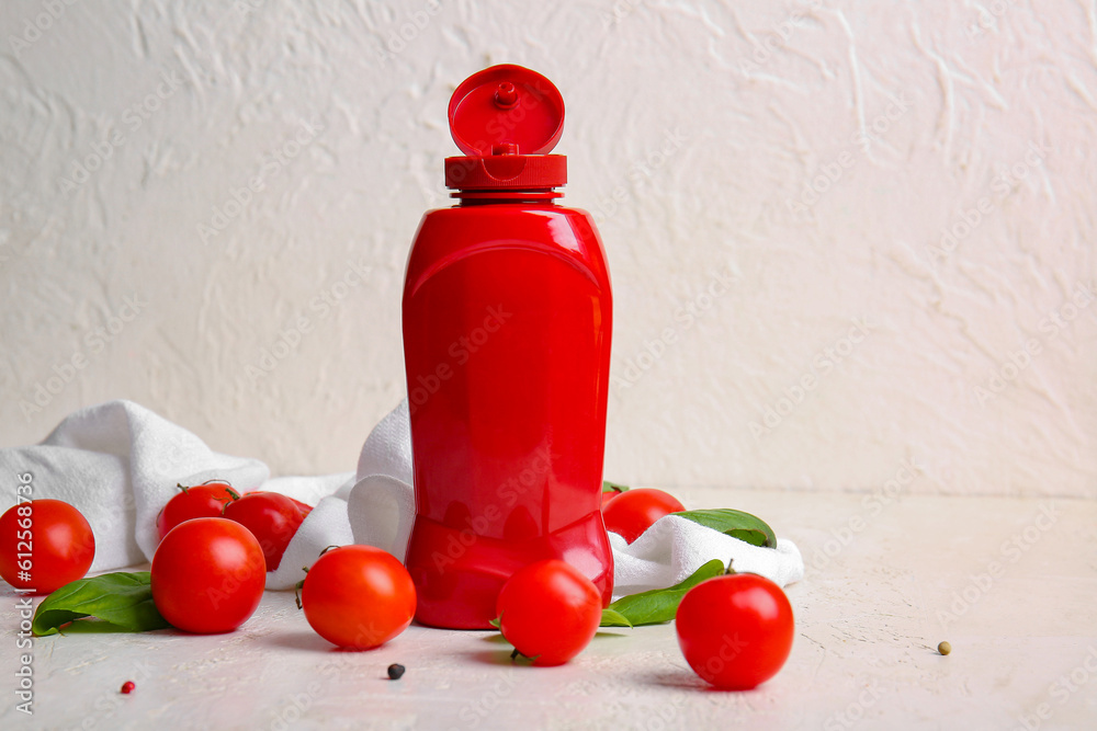 Bottle of ketchup and tomatoes on white background