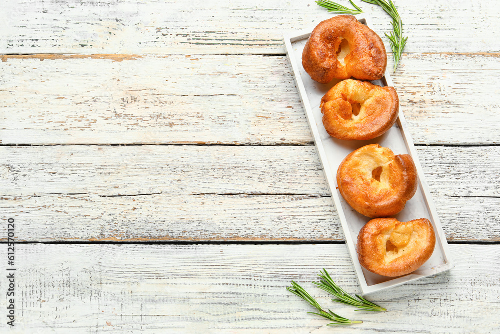 Plate with tasty Yorkshire pudding on light wooden background