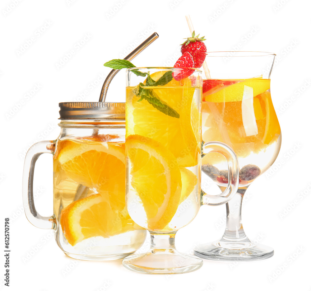 Glasses and mason jar of infused water with orange slices on white background