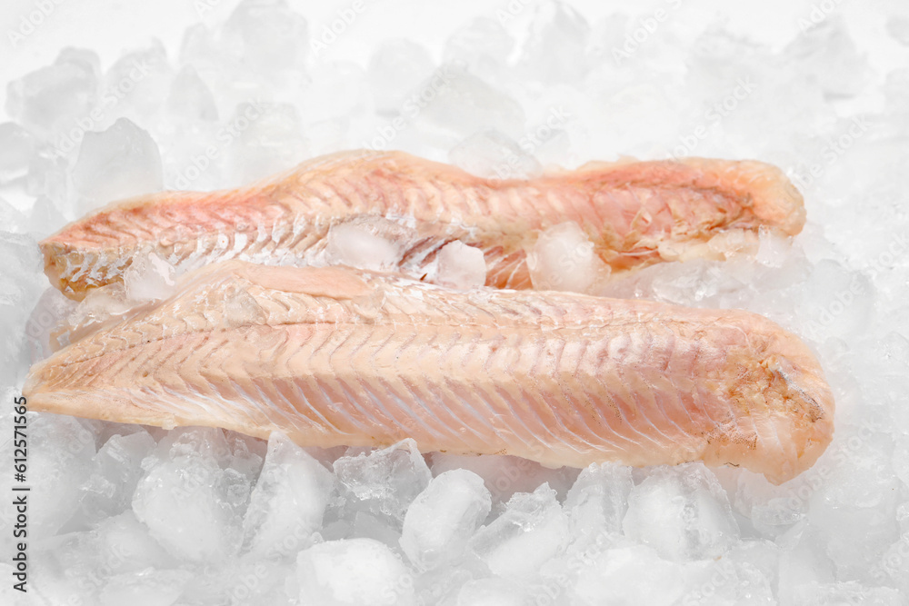 Raw codfish with ice cubes on white background