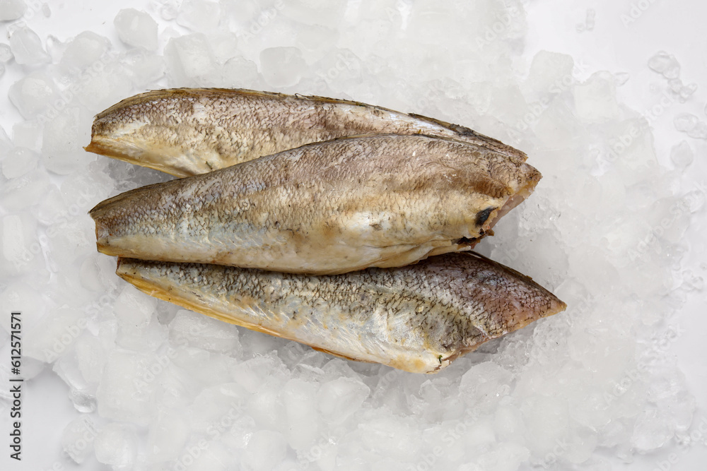 Raw codfish with ice cubes on white background