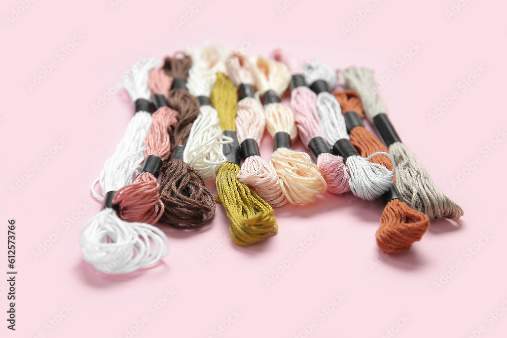 Different colorful mouline threads on pink background