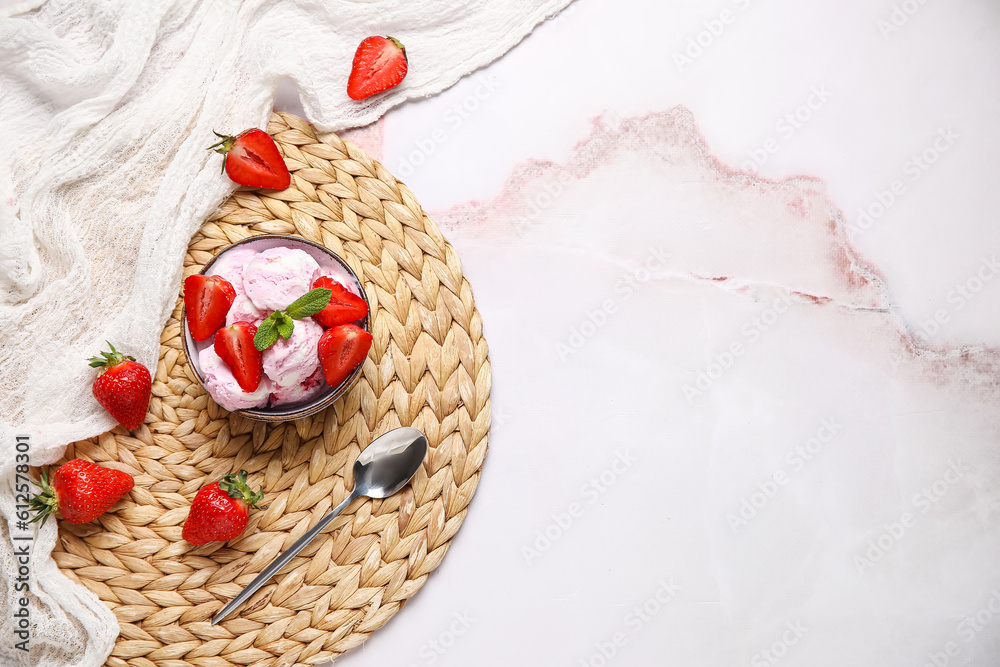 Bowl of strawberry ice cream with berries, mint and spoon on pink table