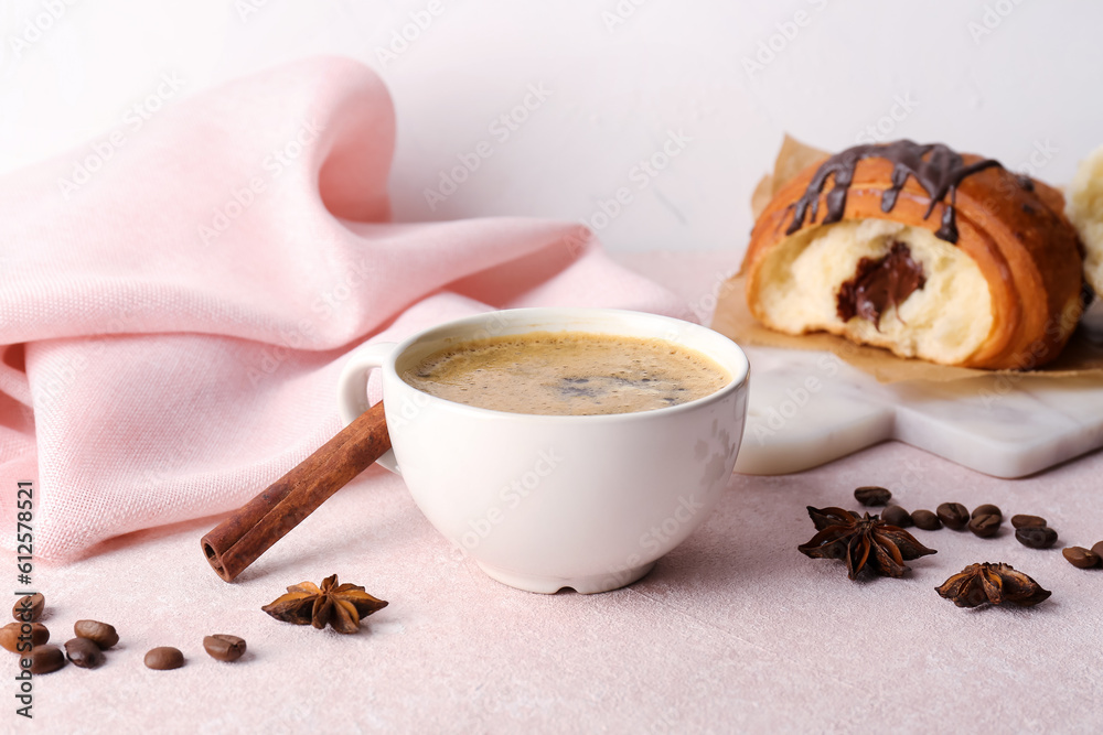 Cup of delicious espresso with spices and croissant on pink background, closeup