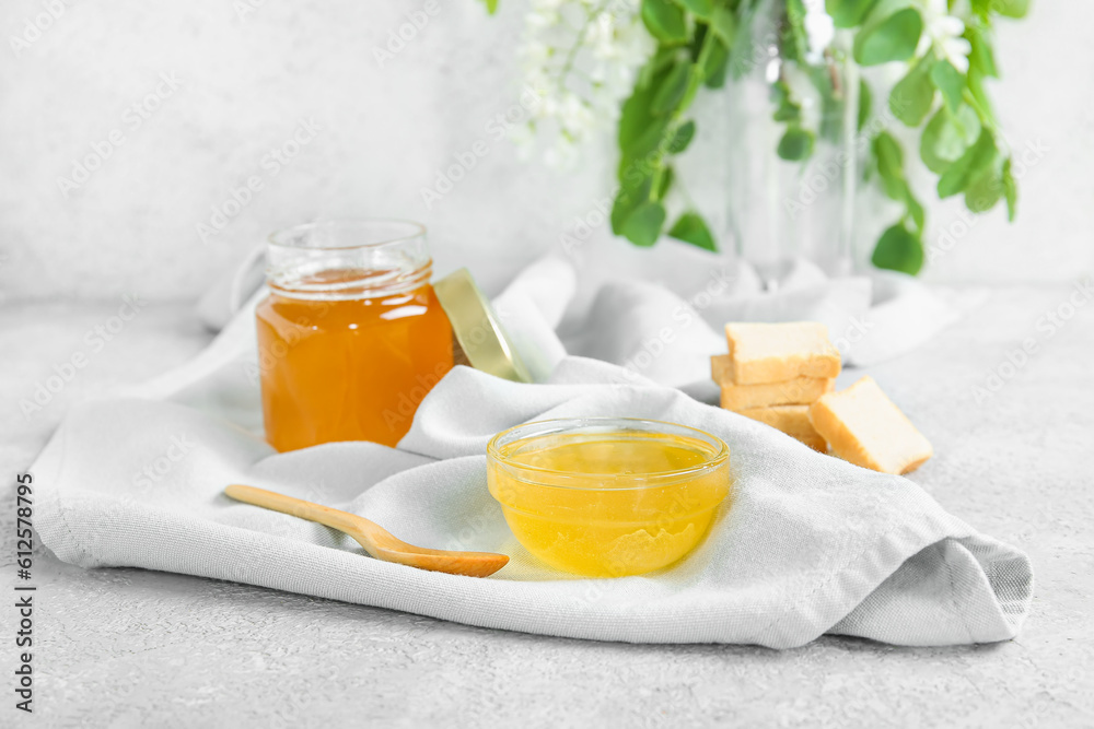 Composition with acacia honey and crackers on light background, closeup