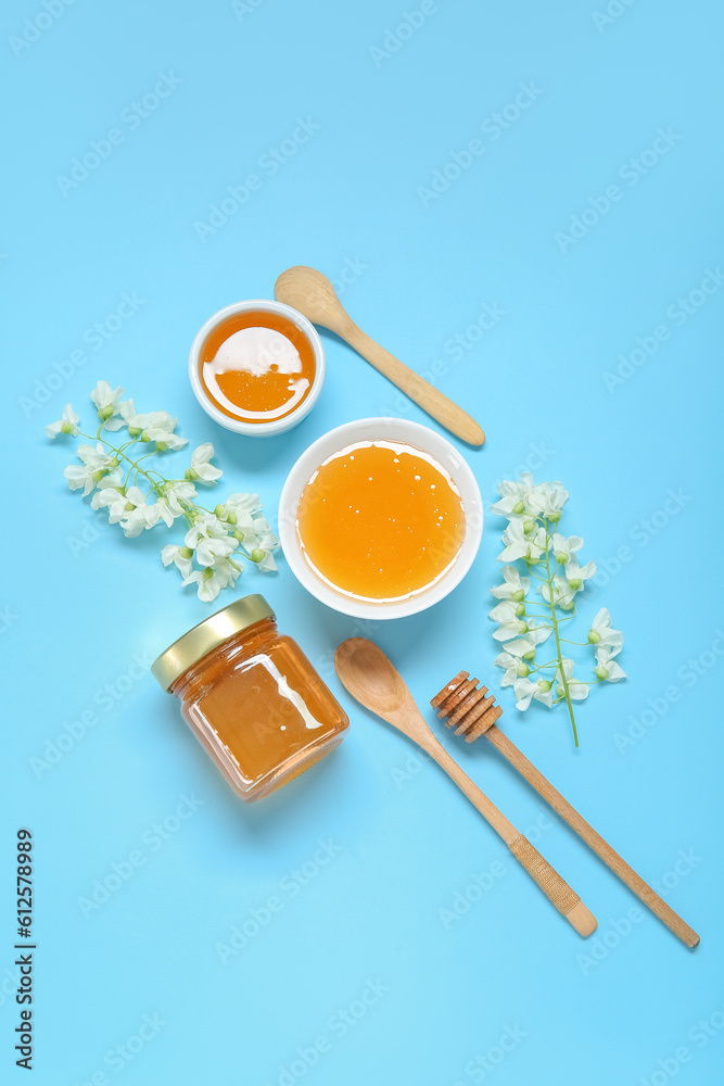 Composition with sweet honey and acacia flowers on blue background