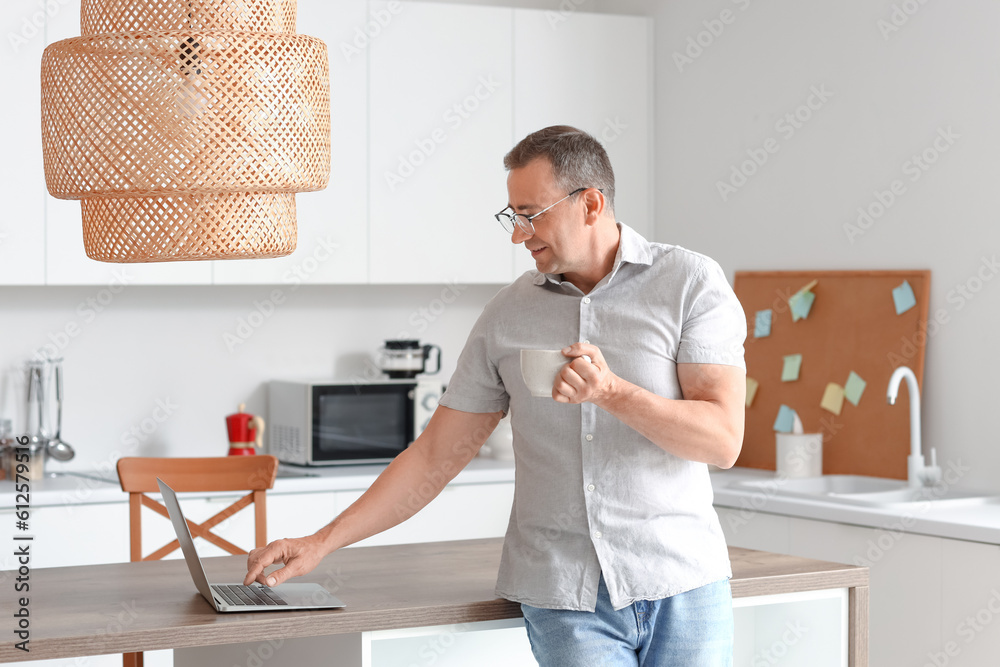 Mature man with eyeglasses and cup of coffee in kitchen