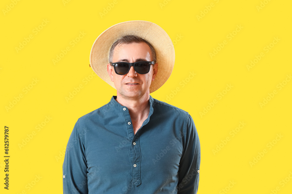 Mature man in sunglasses on yellow background