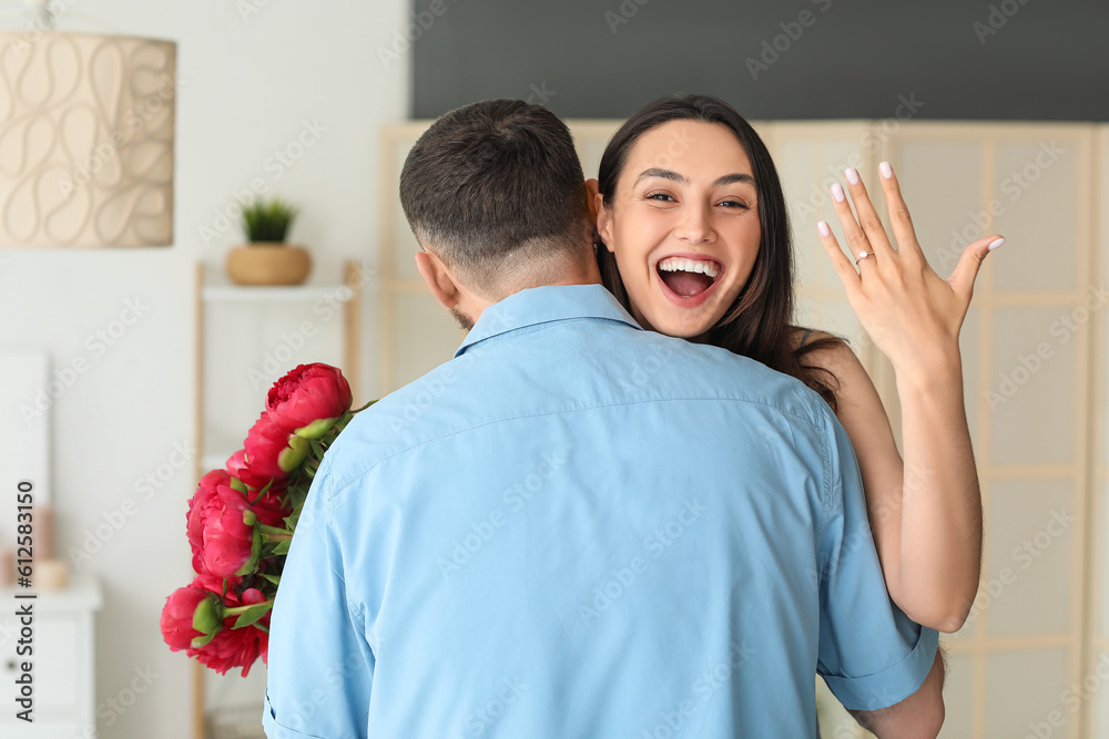 Happy engaged couple hugging at home