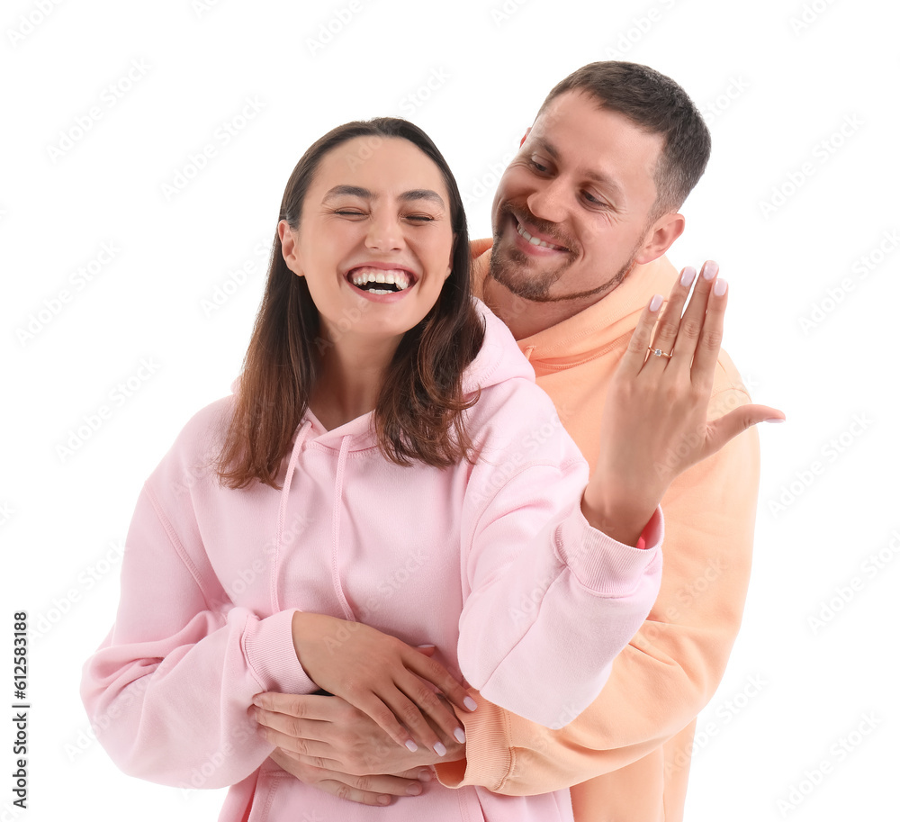 Happy engaged couple hugging on white background