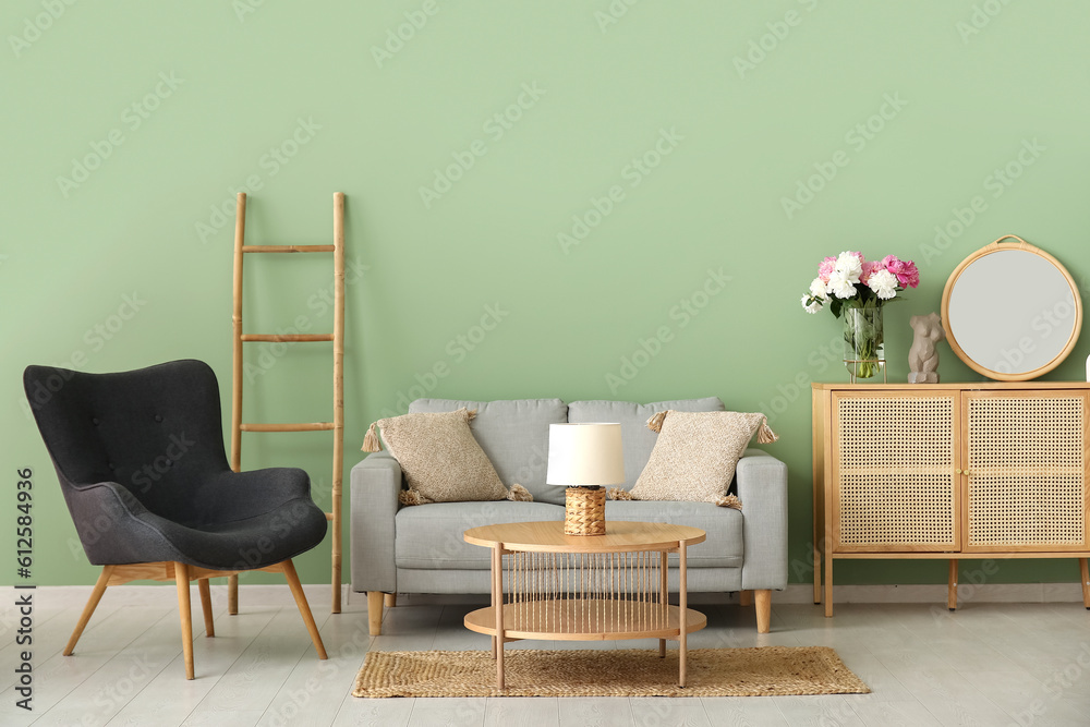 Armchair with couch, dresser and coffee table near green wall