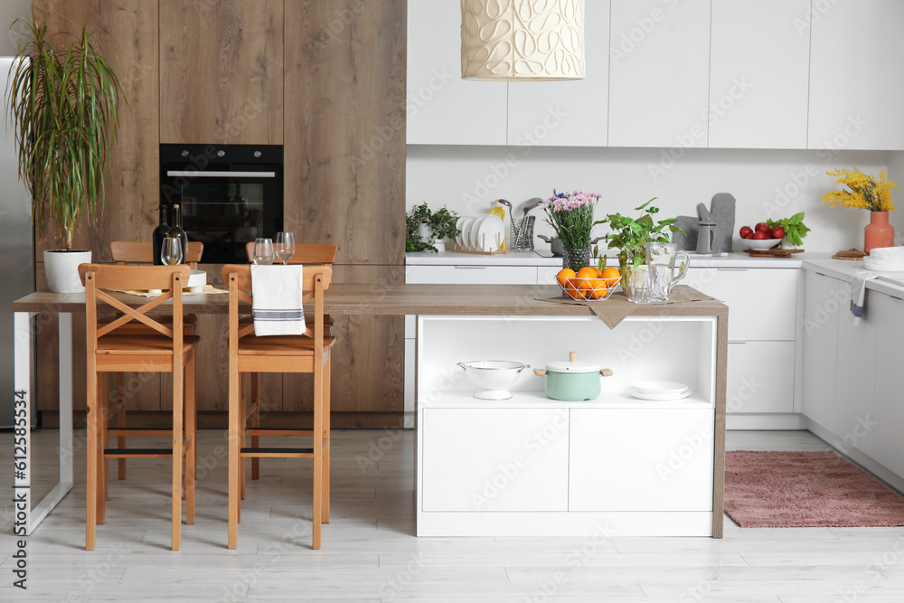 Interior of light kitchen with stylish island table