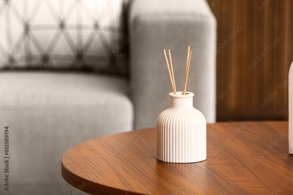 Bottle of reed diffuser on table in room, closeup