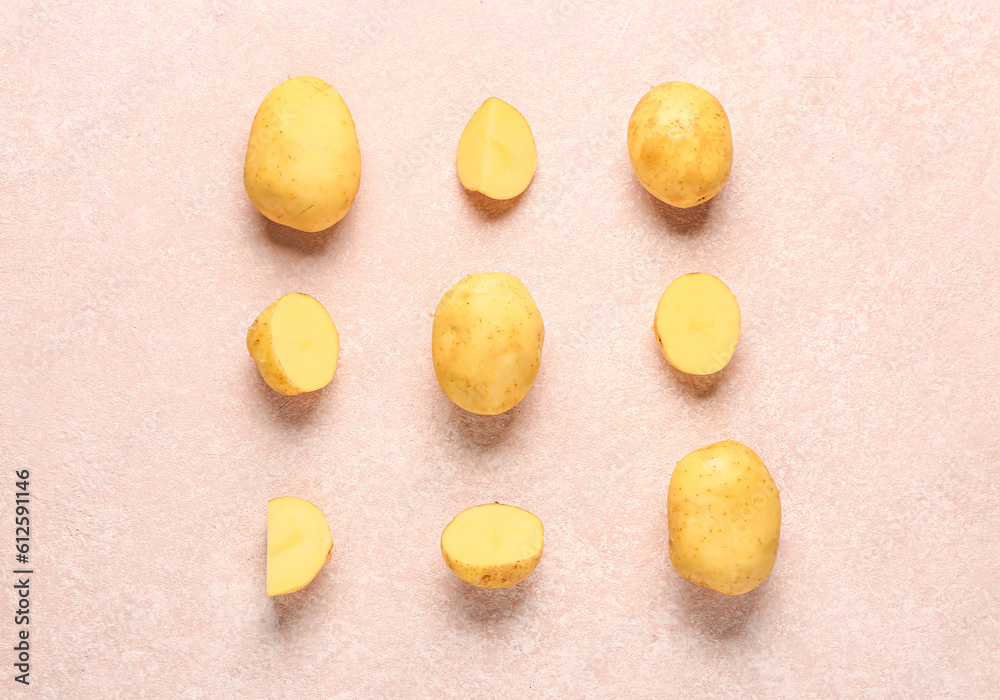 Raw baby potatoes and slices on pink background