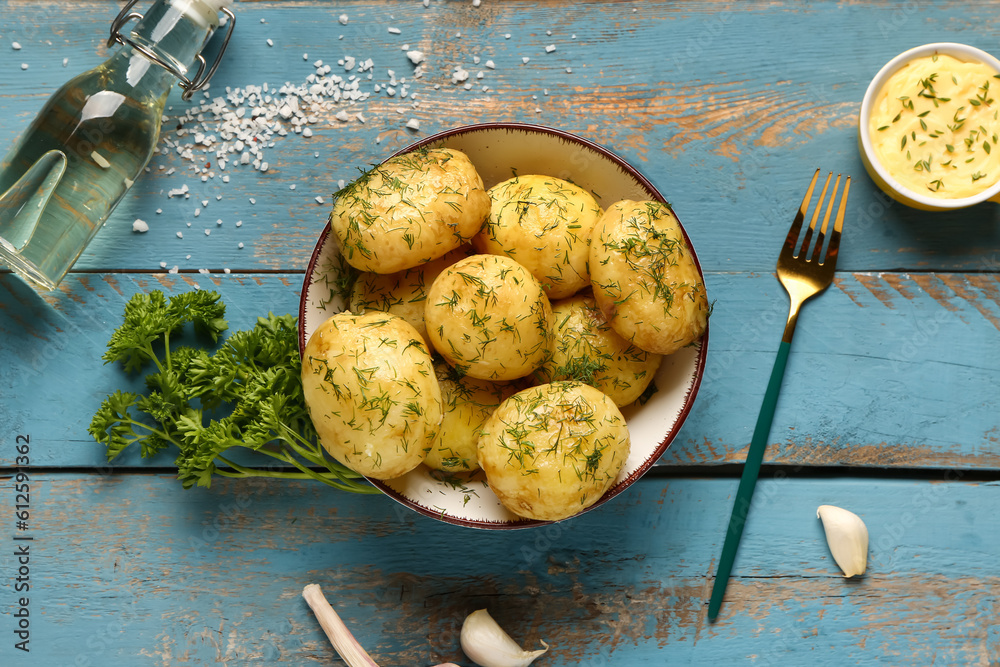 Plate of boiled baby potatoes with dill and parsley on blue wooden background