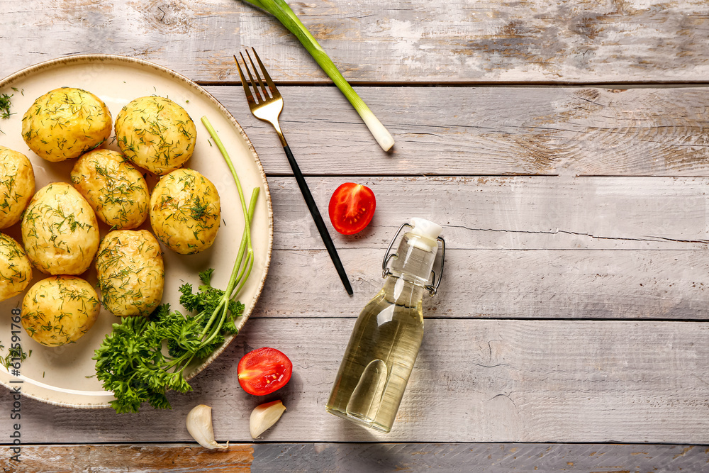 Plate of boiled baby potatoes with dill and tomatoes on grey wooden background