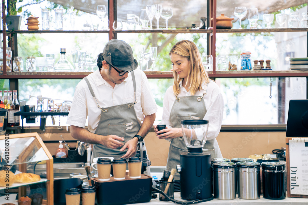 Asian attractive barista and Caucasian waitress working in coffeehouse. 