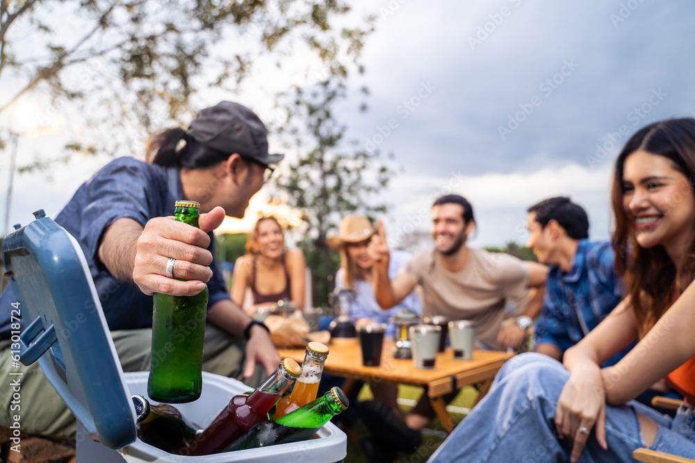 Group of diverse friend having outdoors camping party together in tent. 