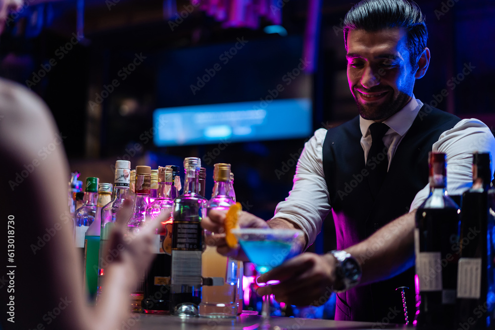 Caucasian profession bartender making a cocktail for women at a bar. 