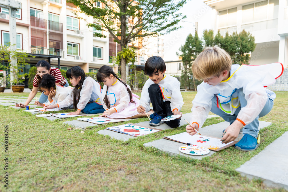 Group of student coloring on painting board outdoors in school garden. 