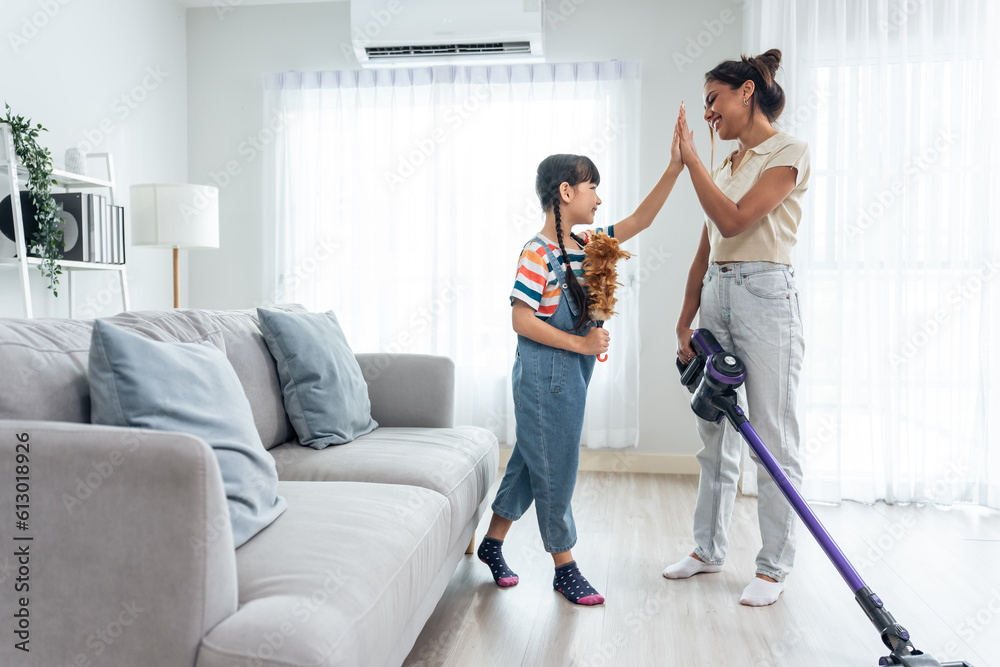 Caucasian beautiful mother cleaning house with young kid daughter. 