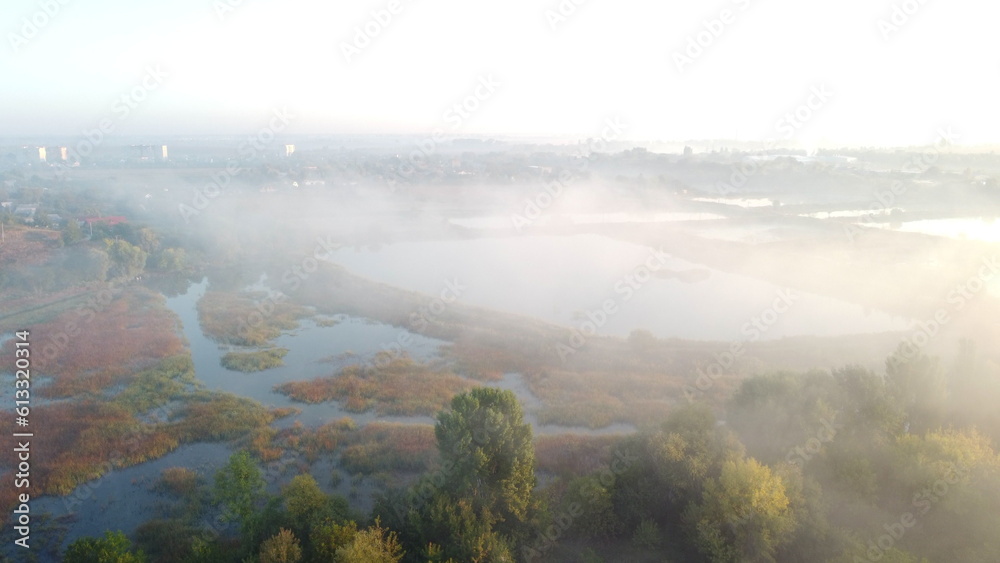 Lakes, artificially created water ponds for growing fish farming with morning mist on an early summe