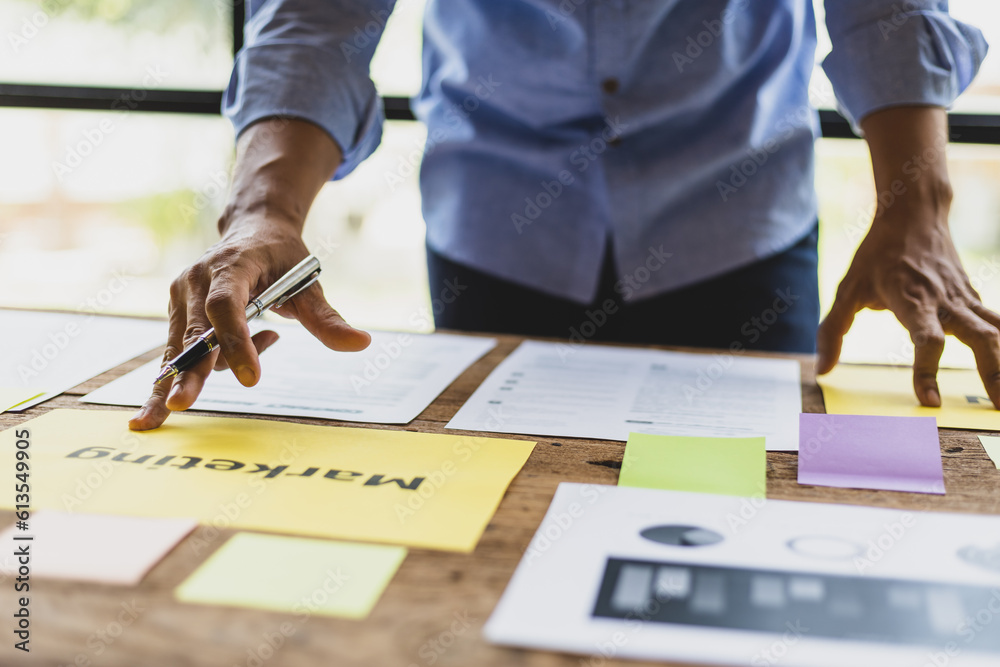 Man working on paperwork on desk, planning marketing business in office.